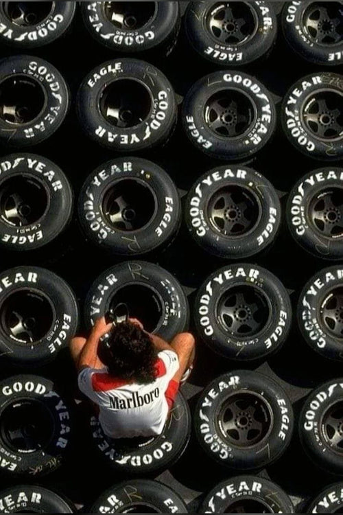 Person standing among rows of Goodyear tires with a Marlboro shirt.