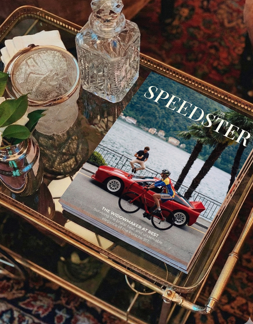 Magazine titled 'Speedster' on a glass table with decorative items.
